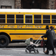 A couple pushing strollers walk past the Yeshiva Kehilath Yakov School South Williamsburg.